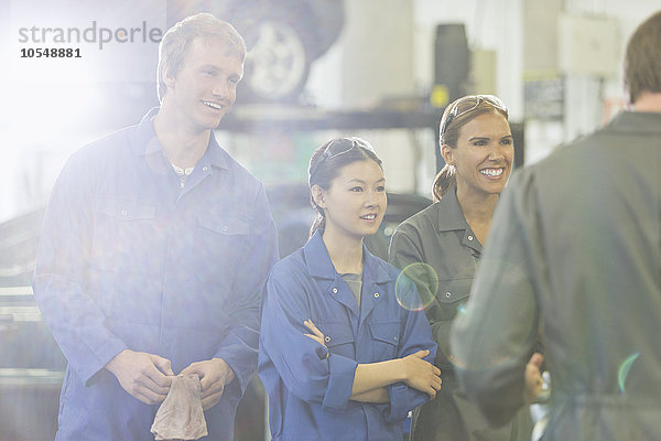 Mechaniker hören in der Autowerkstatt zu