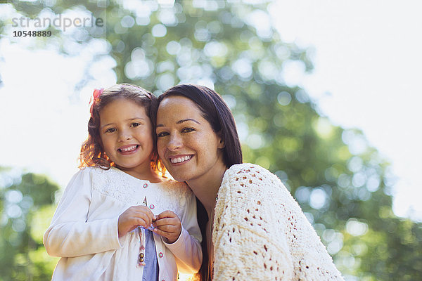 Portrait lächelnde Mutter und Tochter im Freien