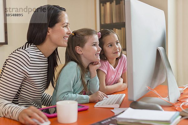 Mutter und Töchter mit Computer