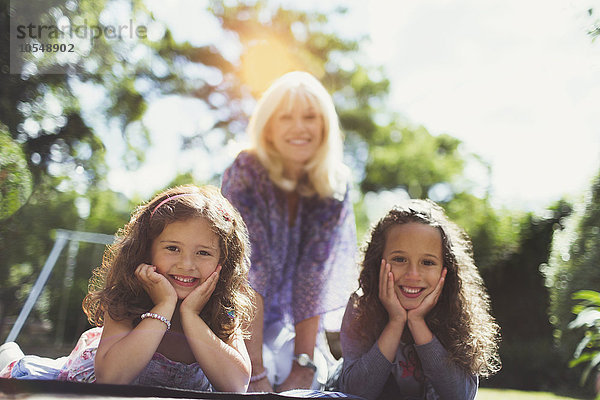 Portrait lächelnde Großmutter mit Zwillingseltern im Park