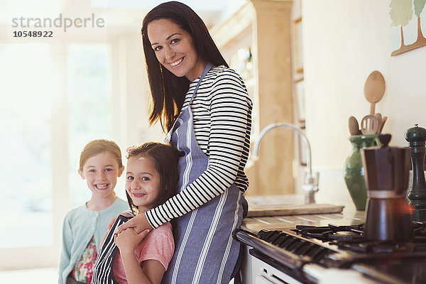 Portrait lächelnde Mutter und Töchter in der Küche