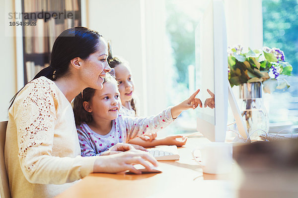 Mutter und Töchter mit Computer