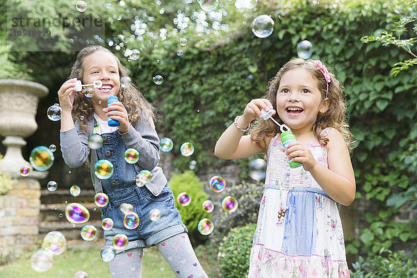 Sorglose Mädchen blasen Blasen im Garten