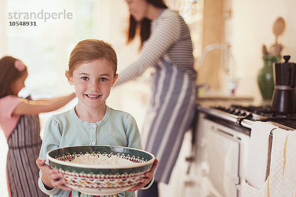 Portrait lächelndes Mädchen beim Backen mit Mehlschale in der Küche