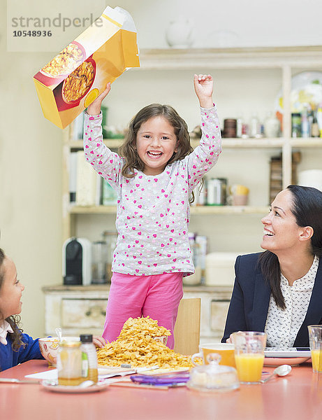 Porträt begeistertes Mädchen mit Müslibox am Frühstückstisch