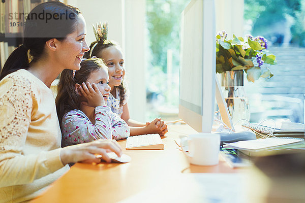 Mutter und Töchter mit Computer