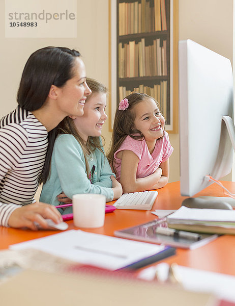 Mutter und Töchter mit Computer