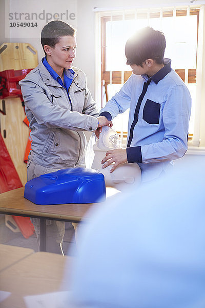 Instructor Guiding Student mit manuellem Beatmungsgerät in der CPR-Schulung