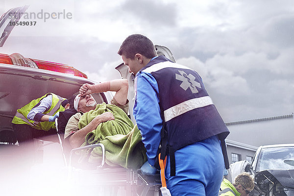 Rettungskräfte beim Verladen des Unfallopfers in den Krankenwagen