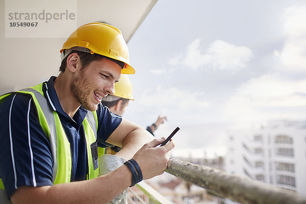 Bauarbeiter texten auf der Hochhausbaustelle