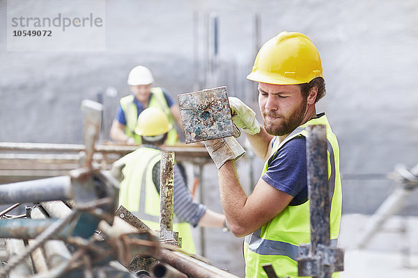 Bauarbeiter mit Metallstange auf der Baustelle