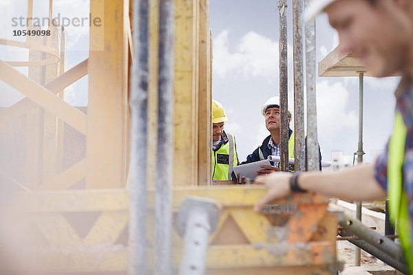 Vorarbeiter mit digitalem Tablett beim Blick auf die Baustelle