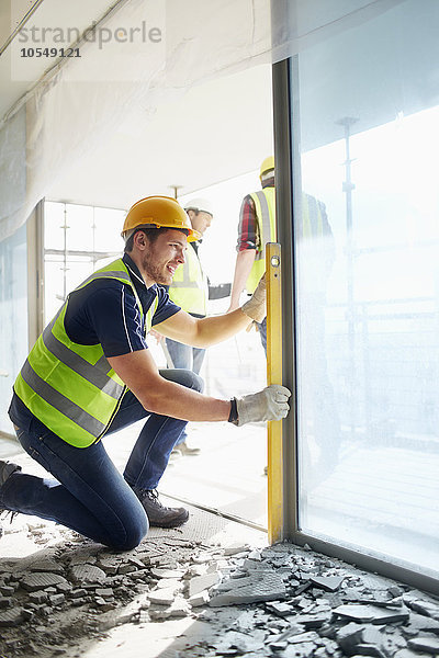 Bauarbeiter mit ebenem Werkzeug auf der Baustelle