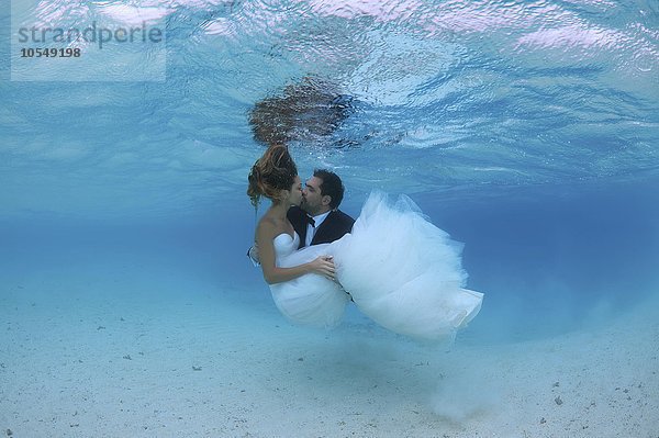 Jungvermählte küssen sich unter Wasser  Indischer Ozean  Malediven  Asien