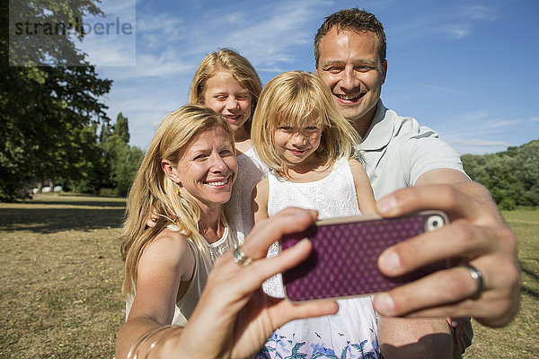 Familie mit zwei Kindern  die ein Selfie nimmt.