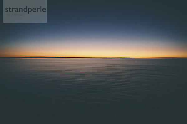 Der Blick über die Oberfläche der Bonneville Salt Flats auf das Licht der Morgendämmerung bei Sonnenaufgang.