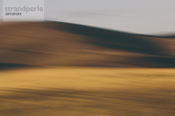 Die Umrisse von sanften Hügeln und Ackerland  verschwommene Bewegung und Licht und Schatten.