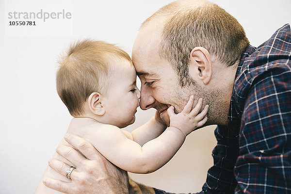 Ein junges Mädchen und ihr Vater stehen sich beim Spielen gegenüber.