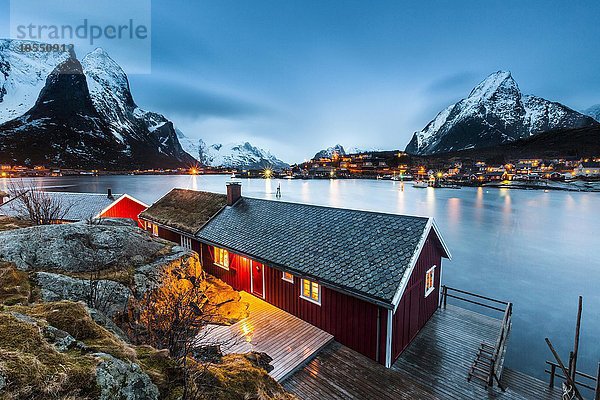 Rotes Haus im Winter mit Blick auf Fjord  Fischerdorf Reine  Rorbuer oder Rorbu  Reinefjord  Moskenesøya  Lofoten  Norwegen  Europa