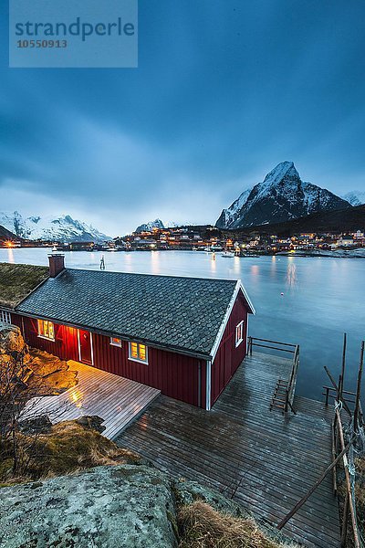 Rotes Haus im Winter mit Blick auf Fjord  Fischerdorf Reine  Rorbuer oder Rorbu  Reinefjord  Moskenesøya  Lofoten  Norwegen  Europa