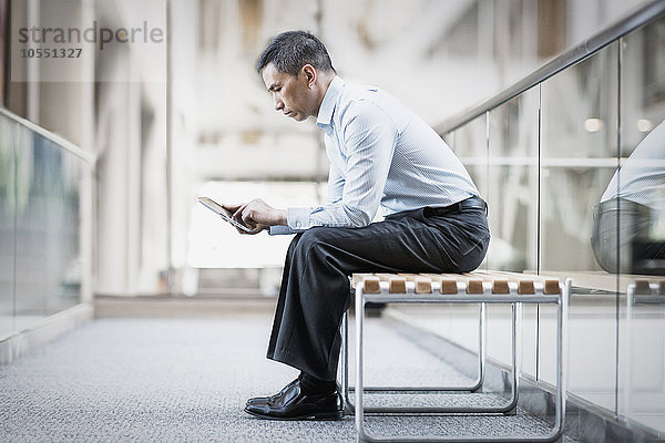 Ein Mann sitzt mit einem digitalen Tablett.