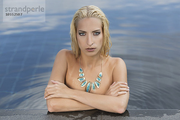 Junge Frau posiert nackt in einem Pool  verdeckter Teilakt  Fashion  Bademode  Portrait