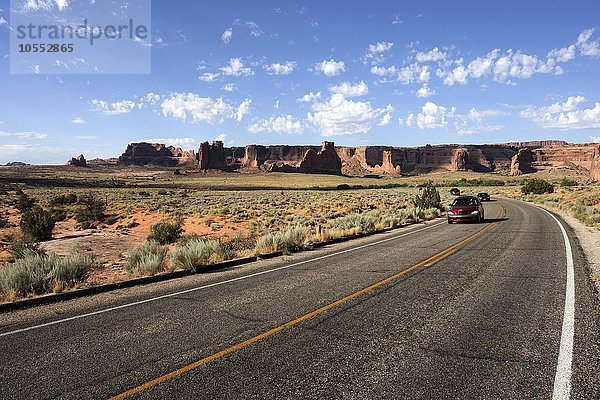 Straße mit Auto  Arches Science Drive  hinten die Courthouse Towers  Arches National Park  Utah  USA  Nordamerika