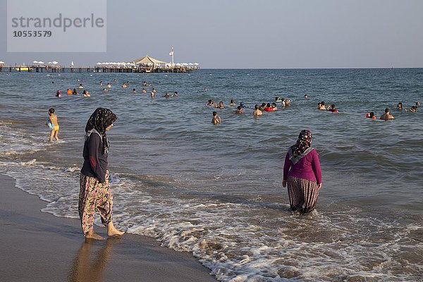 Türkinnen gehen mit Kleidung im Meer baden  Side-Sorgun  Side Belediyesi  türkische Riviera  Antalya  Türkei  Asien