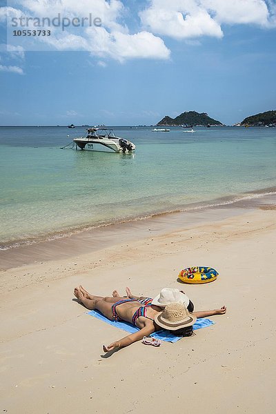 Mutter und Kind liegen am Sandstrand  Sairee Beach  türkises Meer  Insel Koh Tao  Golf von Thailand  Thailand  Asien
