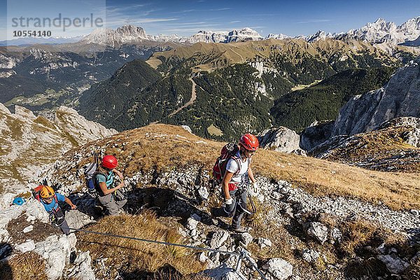 Bergsteiger beim Aufstieg auf die Cima Valacia über den Kletterstieg Via Ferrata F. Gadotti im Val San Nicolo im Fassatal  hinten Langjofel und Plattkofel und die Sellagruppe  Pozza di Fassa  Dolomiten  Trentino  Trentino-Südtirol  Italien  Europa