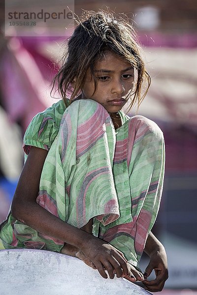 Ein trauriges Mädchen sitzt auf einer Mauer  Portrait  Pushkar  Rajasthan  Indien  Asien