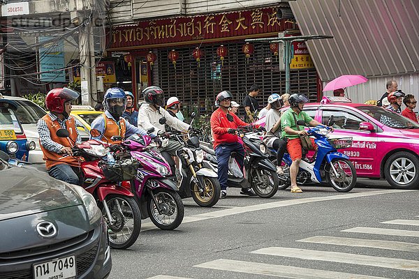 Straßenszene  Motorroller warten am Zebrastreifen an viel befahrener Straße  Verkehr  Bangkok  Thailand  Asien