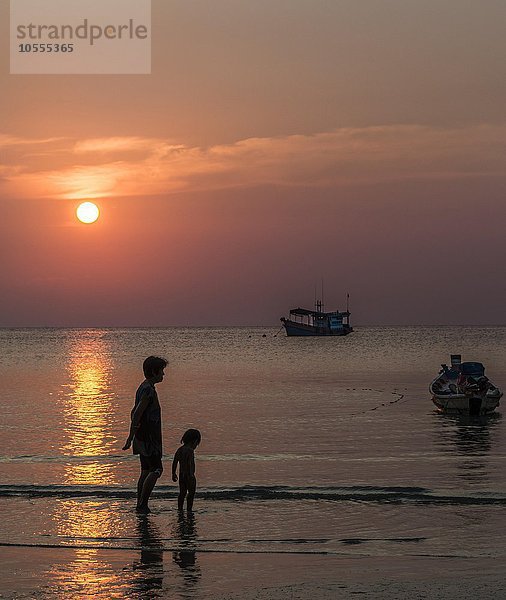 Frau mit Kind am Strand im Wasser  Boote im Meer bei Sonnenuntergang  Insel Koh Tao  Südchinesisches Meer  Golf von Thailand  Thailand  Asien