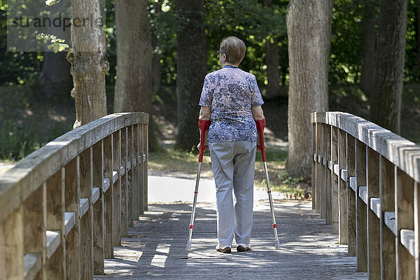 Ältere Frau geht an Krücken  Deutschland  Europa