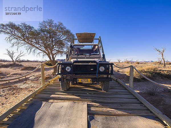 Landrover fährt über eine Holzbrücke im Kulala Wilderness Reserve am Rande der Namib Wüste  Hardap  Namibia  Afrika
