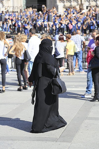 Orientalische Frau  gekleidet in schwarzer Burka  Menschenmenge  Piazza del Duomo  Mailand  Lombardei  Italien  Europa