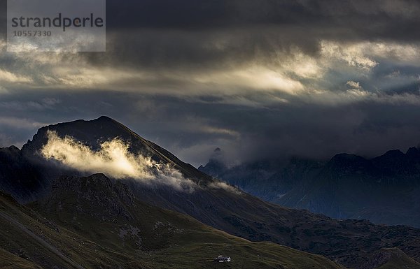 Wolke mit Sonnenspot vor dunklem Berggipfel  Allgäuer Alpen  Warth  Vorarlberg  Österreich  Europa