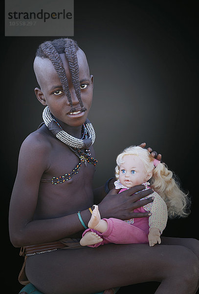 Schwarzes Mädchen spielt mit Babypuppe