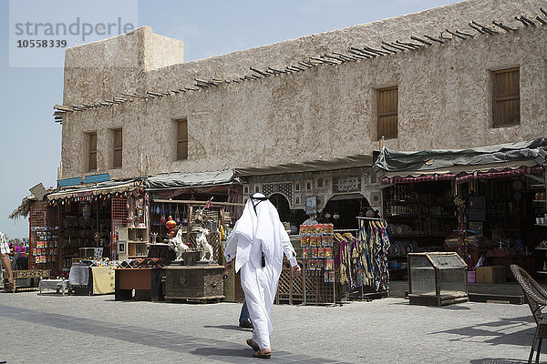 Mann  der vor dem Markt auf dem Bürgersteig von Doha spazieren geht  Doha  Katar