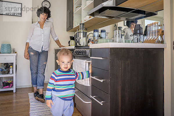 Kaukasische Mutter beobachtet ihren kleinen Sohn in der Küche