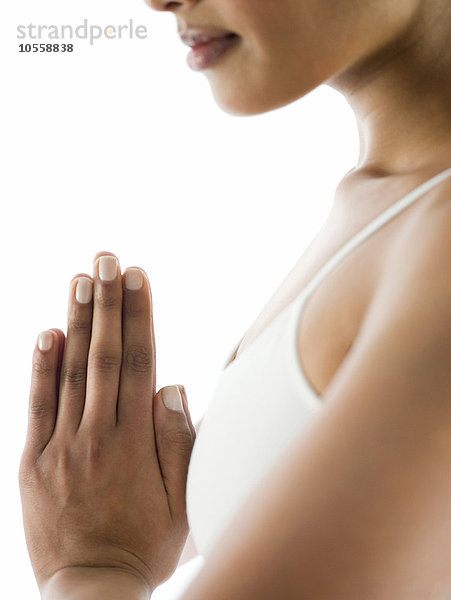 Nahaufnahme einer ruhigen  meditierenden Frau mit verschränkten Händen
