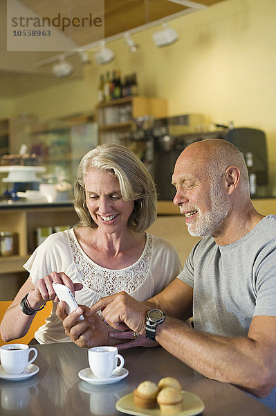 Älteres Paar telefoniert in einem Café