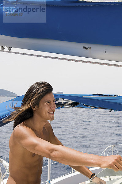 Lächelnder Mann auf dem Deck eines Segelboots