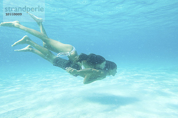 Unterwasseransicht eines im Meer schwimmenden Paares