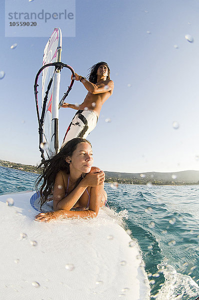 Niedriger Blickwinkel auf ein Paar beim Windsurfen auf dem Meer