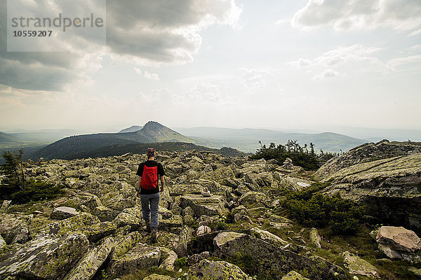 Kaukasischer Wanderer in felsigem Feld in abgelegener Landschaft