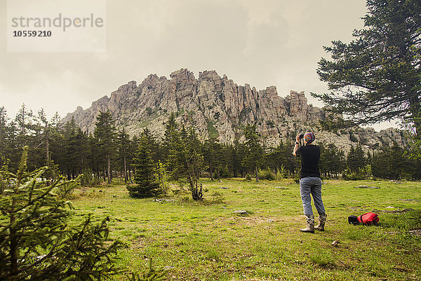 Kaukasischer Wanderer fotografiert Berg in abgelegener Landschaft