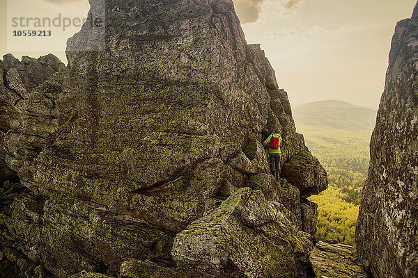 Kaukasischer Wanderer  der auf eine Felsformation klettert