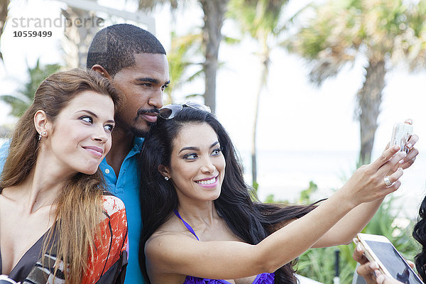 Freunde nehmen Selfie mit Handy im Freien