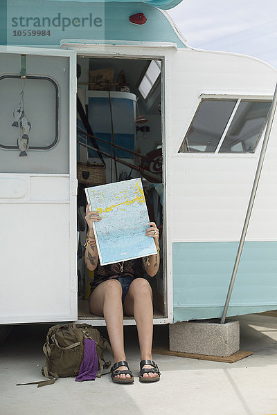 Kaukasische Frau liest Karte im Wohnwagen